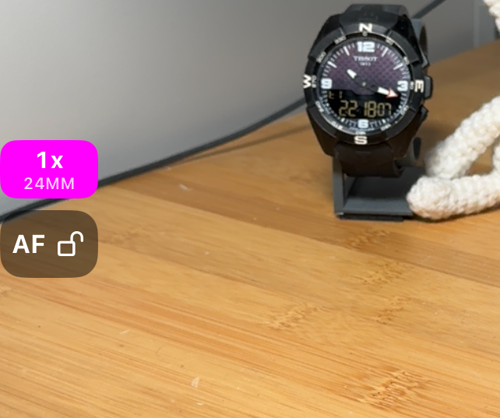 Der linke Rand des Suchers: die AF-Taste mit offenem Schloss und darüber der Zoom-Chip mit 1x und 24MM