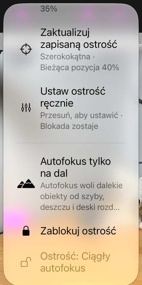 Opcje ostrości otwarte z przycisku AF: „Zablokuj na zapisanej ostrości”, „Zaktualizuj zapisaną ostrość”, „Ustaw ostrość ręcznie”, „Autofokus tylko na dal”, „Zablokuj ostrość” oraz wiersz stanu